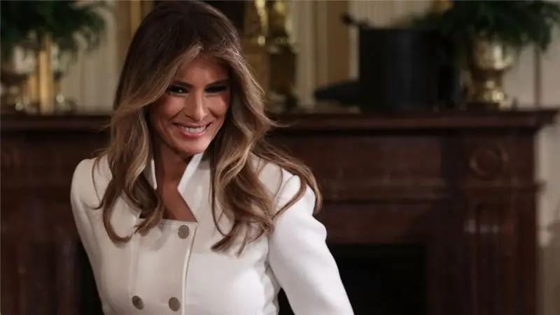 Мелания Трамп в белом бушлате улыбается, глядя вниз